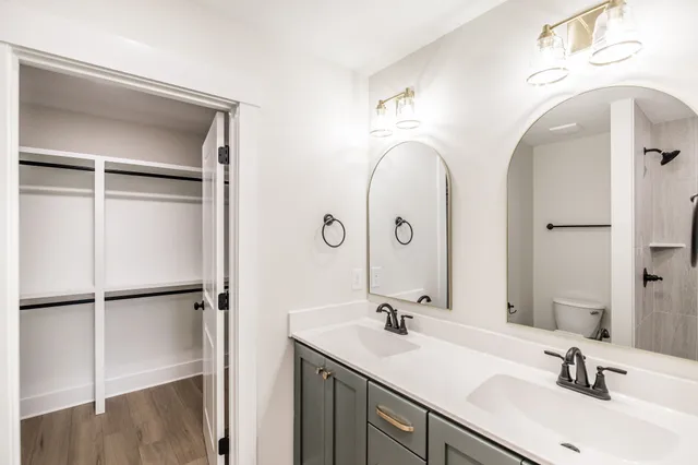 a bathroom with a double vanity sink mirror and shower