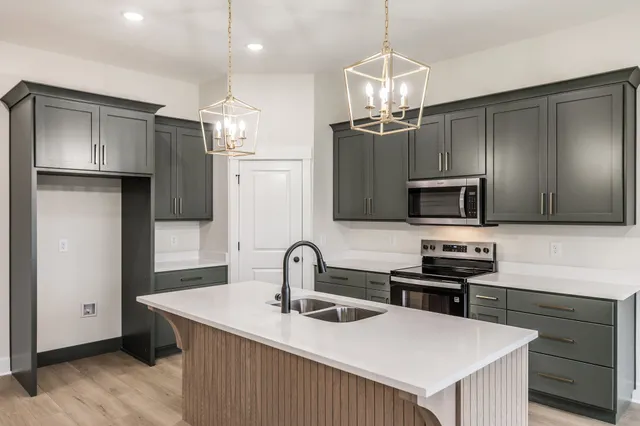 a kitchen with stainless steel appliances a sink stove and refrigerator