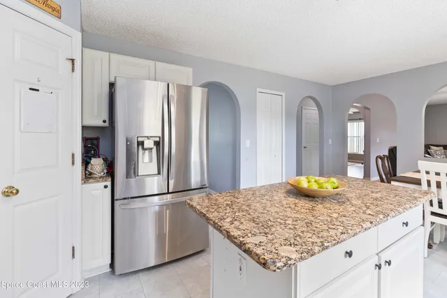 a kitchen with refrigerator and chandelier