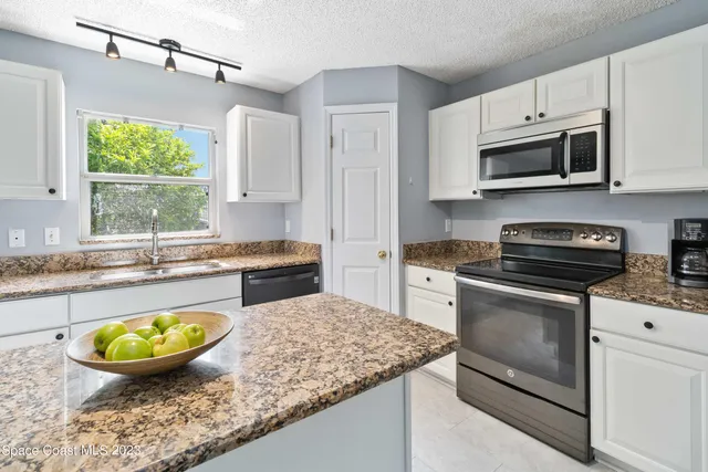a kitchen with stainless steel appliances granite countertop a stove a microwave and a sink