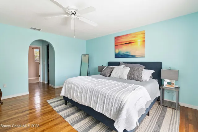 a bedroom with bed and wooden floor