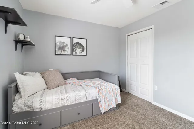 a bedroom with a bed and a painting on the wall