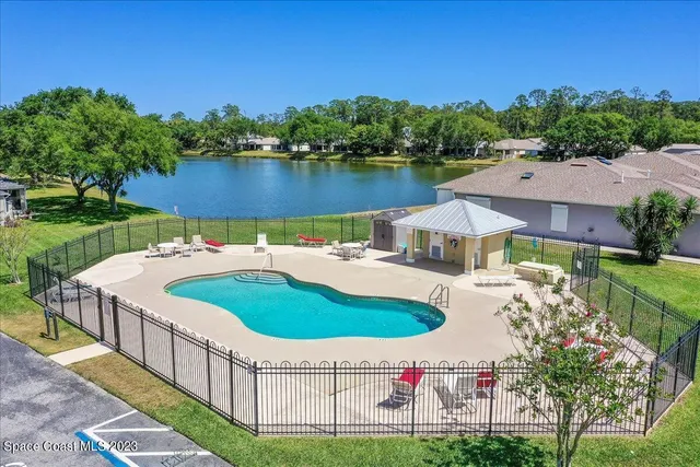 a view of a house with pool and a yard
