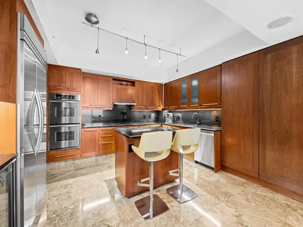 a kitchen with stainless steel appliances granite countertop a sink refrigerator and cabinets