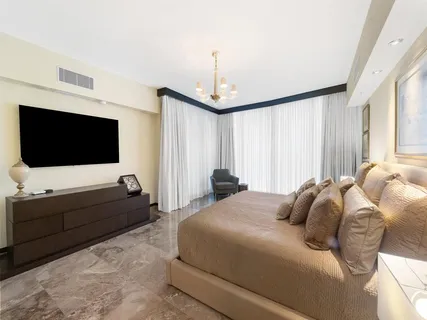 a bedroom with a bed tv and window