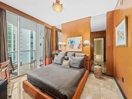 a bedroom with a bed and a large window