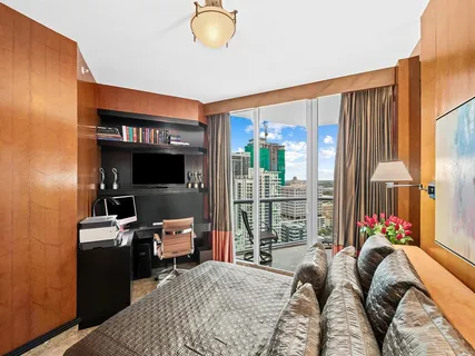 a bedroom with a bed and large windows