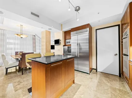 a kitchen with stainless steel appliances granite countertop a sink and a refrigerator