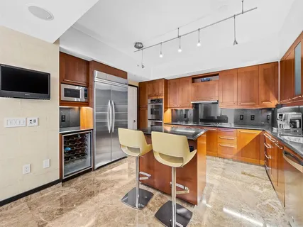 a dining room with a flat screen tv and kitchen view
