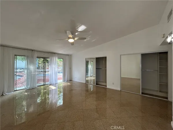 an empty room with closet and a window