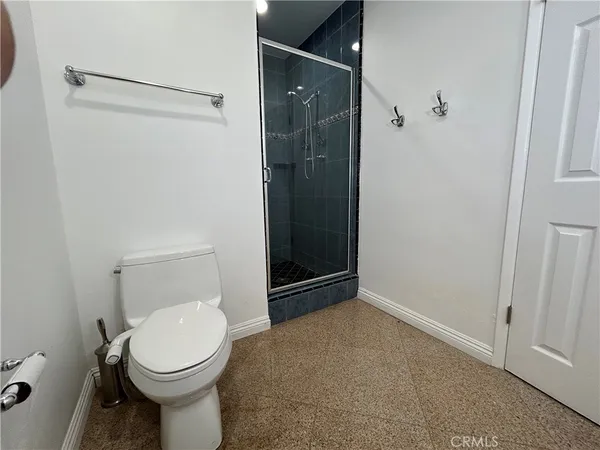 a bathroom with a granite countertop toilet a sink and a shower