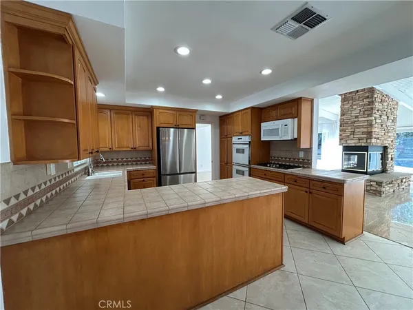 a kitchen with stainless steel appliances granite countertop a refrigerator and a stove top oven