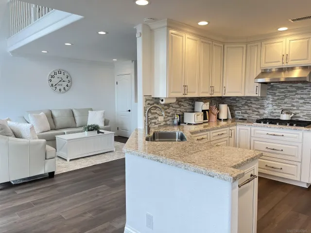 a kitchen with white cabinets and sink
