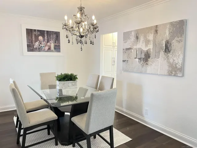 a view of a dining room with furniture a chandelier and wooden floor