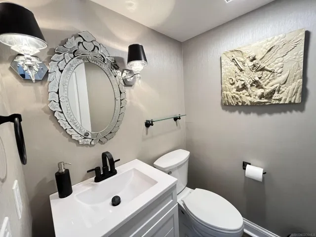 a bathroom with a sink a toilet and a mirror