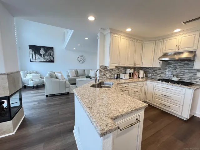 a kitchen with granite countertop white cabinets and white appliances