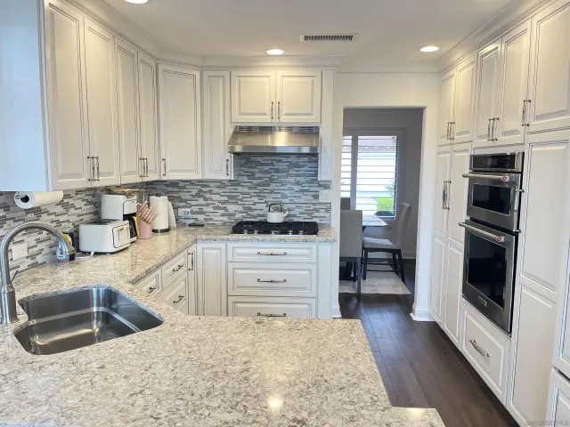 a kitchen with granite countertop a sink stainless steel appliances and cabinets