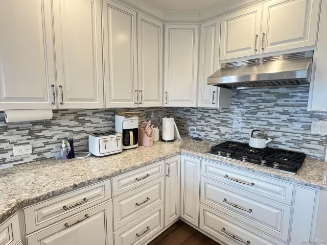 a kitchen with granite countertop white cabinets and white appliances
