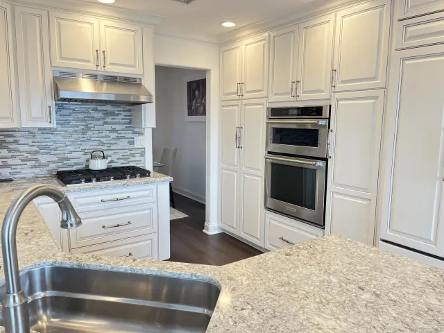 a kitchen with stainless steel appliances kitchen island granite countertop a stove a sink and a refrigerator