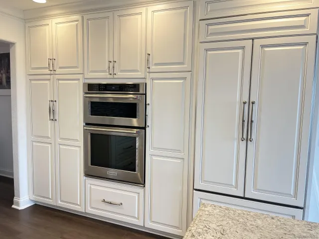a kitchen with granite countertop white cabinets and stainless steel appliances