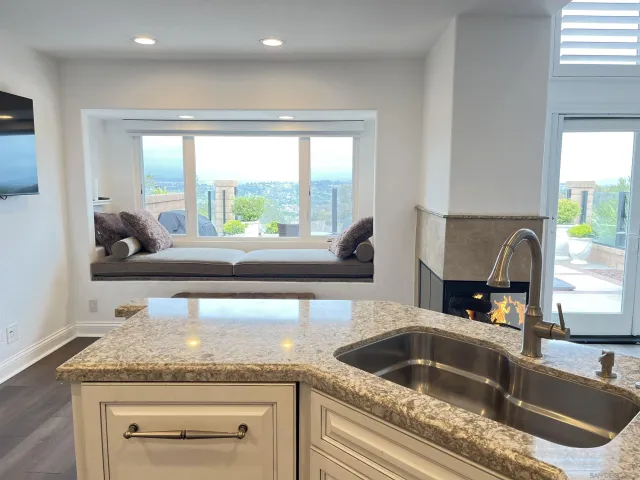 a kitchen with a granite countertop sink and a window
