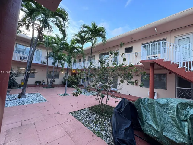a view of an house with backyard and sitting area