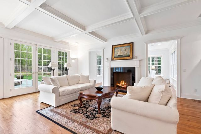a living room with furniture a large window and a fireplace