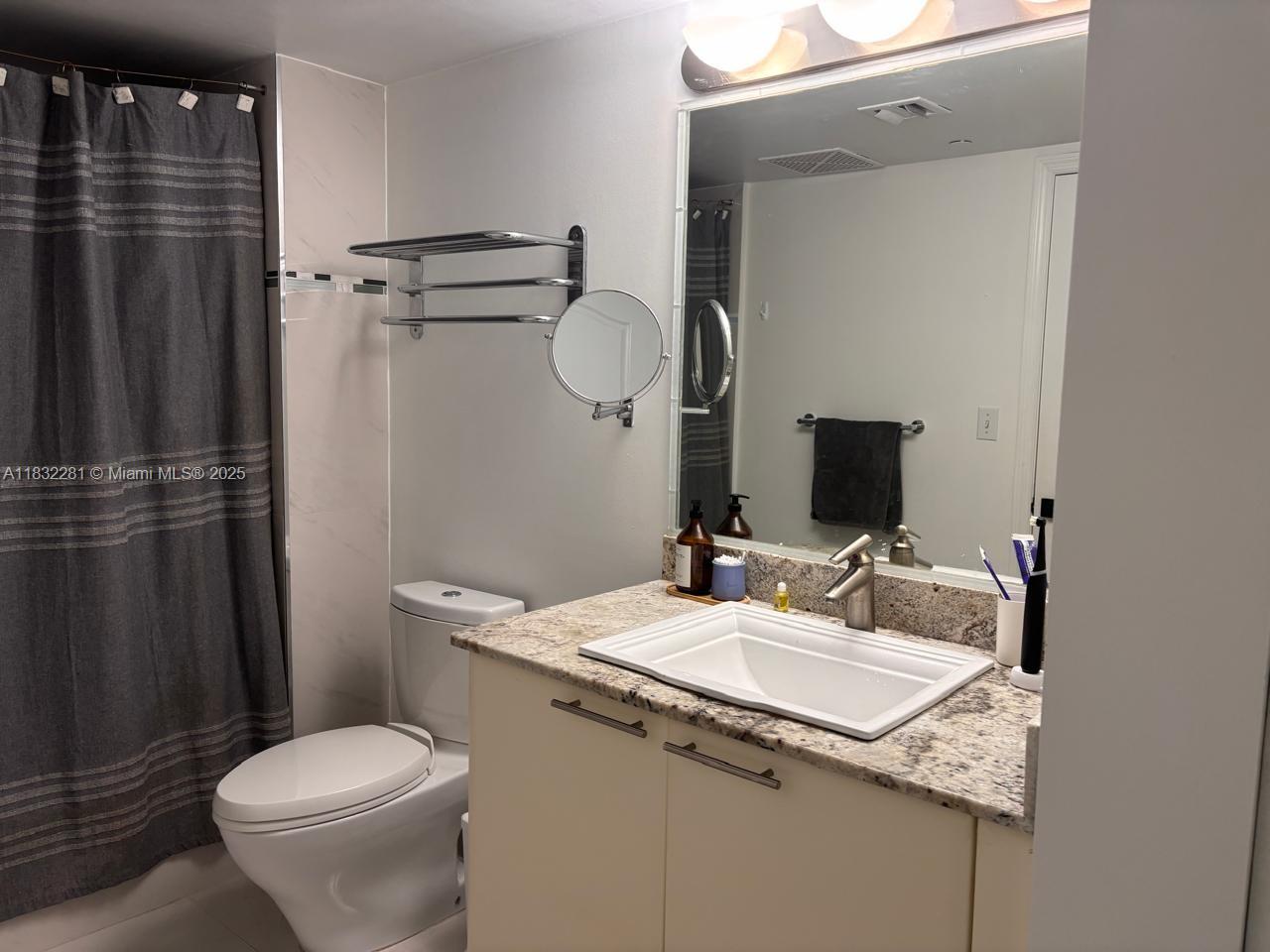2101 Brickell Avenue, Unit 903 Miami, FL 33129 - Photo 13 of 22 a bathroom with a granite countertop sink toilet and shower