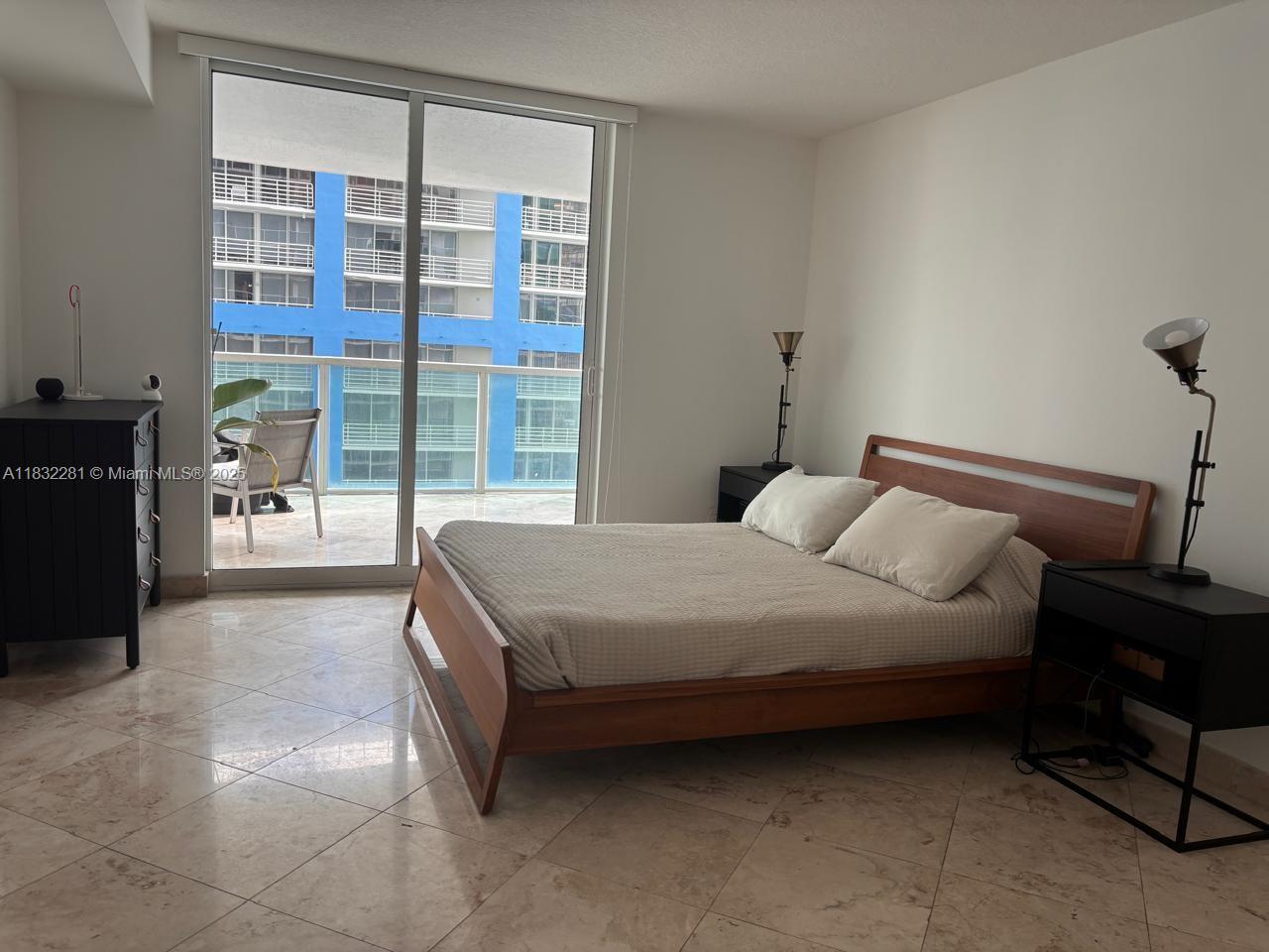 2101 Brickell Avenue, Unit 903 Miami, FL 33129 - Photo 14 of 22 a bedroom with a bed and glass door