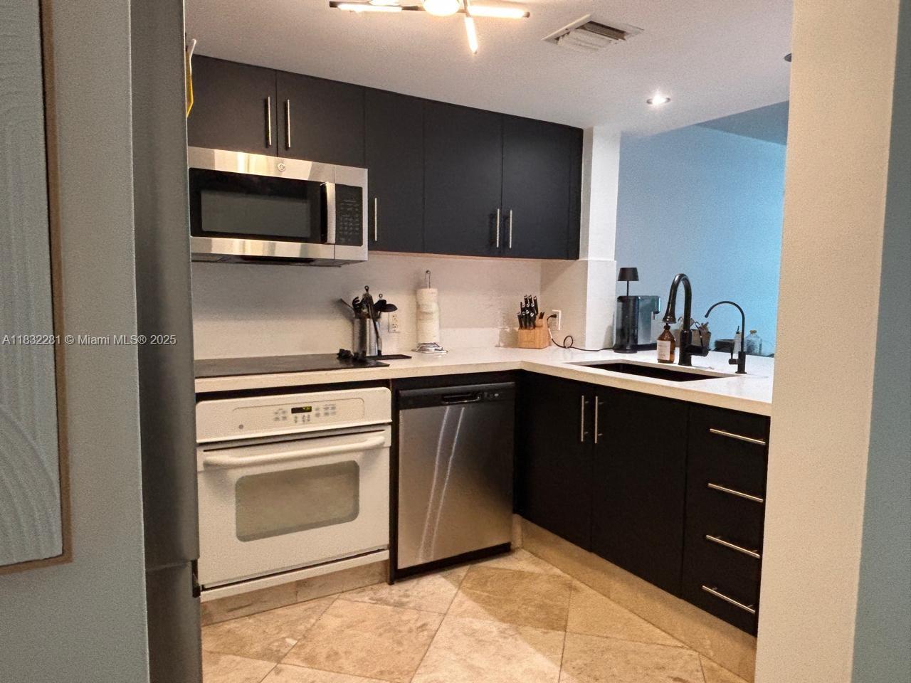 2101 Brickell Avenue, Unit 903 Miami, FL 33129 - Photo 18 of 22 a kitchen with a sink and stainless steel appliances