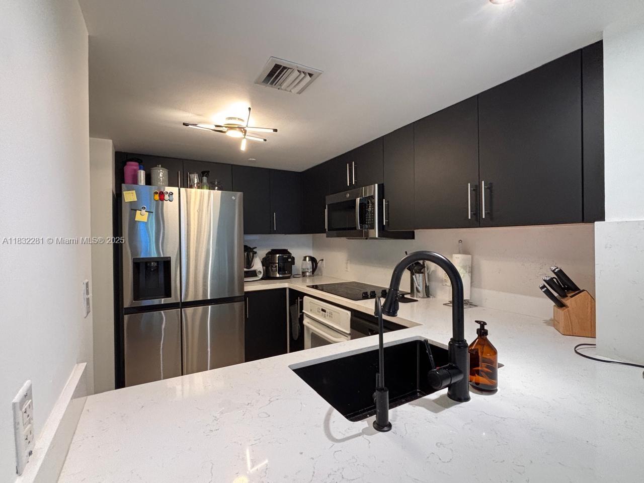 2101 Brickell Avenue, Unit 903 Miami, FL 33129 - Photo 19 of 22 a kitchen with stainless steel appliances kitchen island granite countertop a refrigerator and a sink