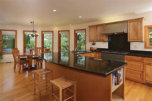 51 Dudley Road Newton, MA 02459 - Photo 5 of 12 a kitchen with granite countertop a stove a sink a dining table and chairs with wooden floor