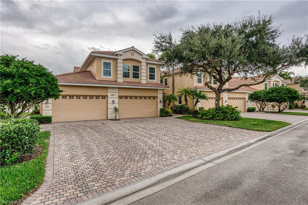 6017 Trophy Drive, Unit 603 Naples, FL 34110 - Photo 2 of 23 a front view of a house with a yard and garage