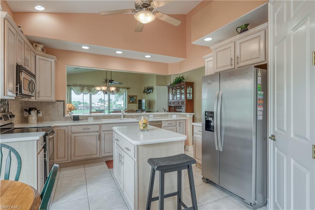 6017 Trophy Drive, Unit 603 Naples, FL 34110 - Photo 6 of 23 a kitchen with kitchen island granite countertop a sink appliances cabinets and furniture