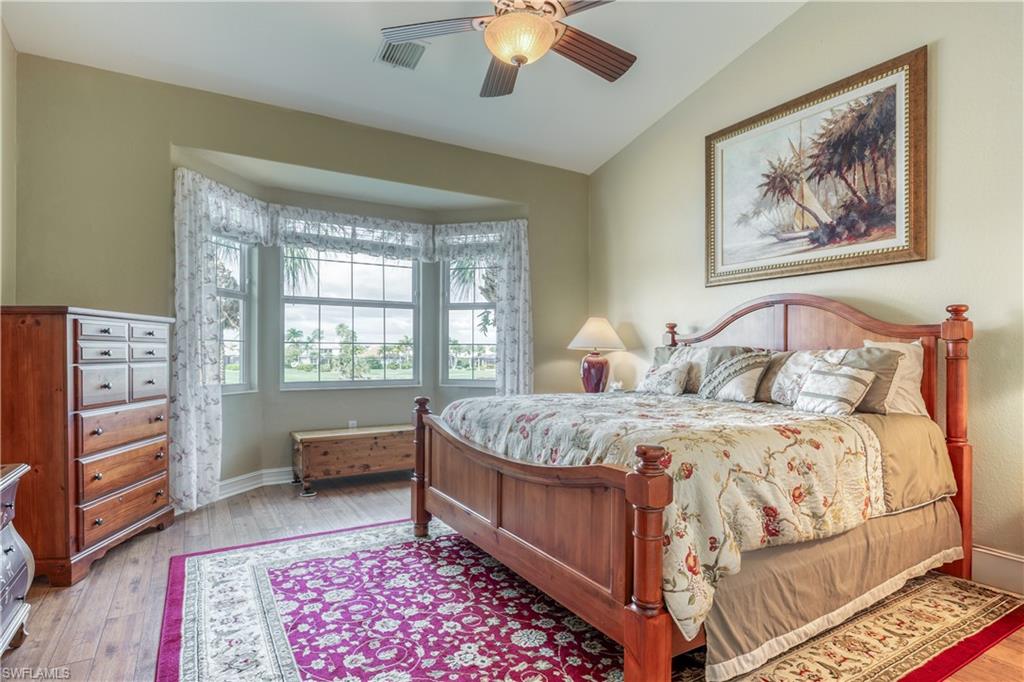 6017 Trophy Drive, Unit 603 Naples, FL 34110 - Photo 7 of 23 a bedroom with a bed and a chandelier