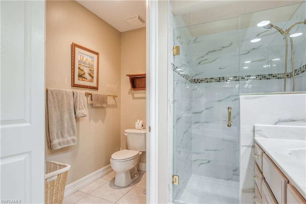 6017 Trophy Drive, Unit 603 Naples, FL 34110 - Photo 8 of 23 a bathroom with a granite countertop toilet a sink and shower