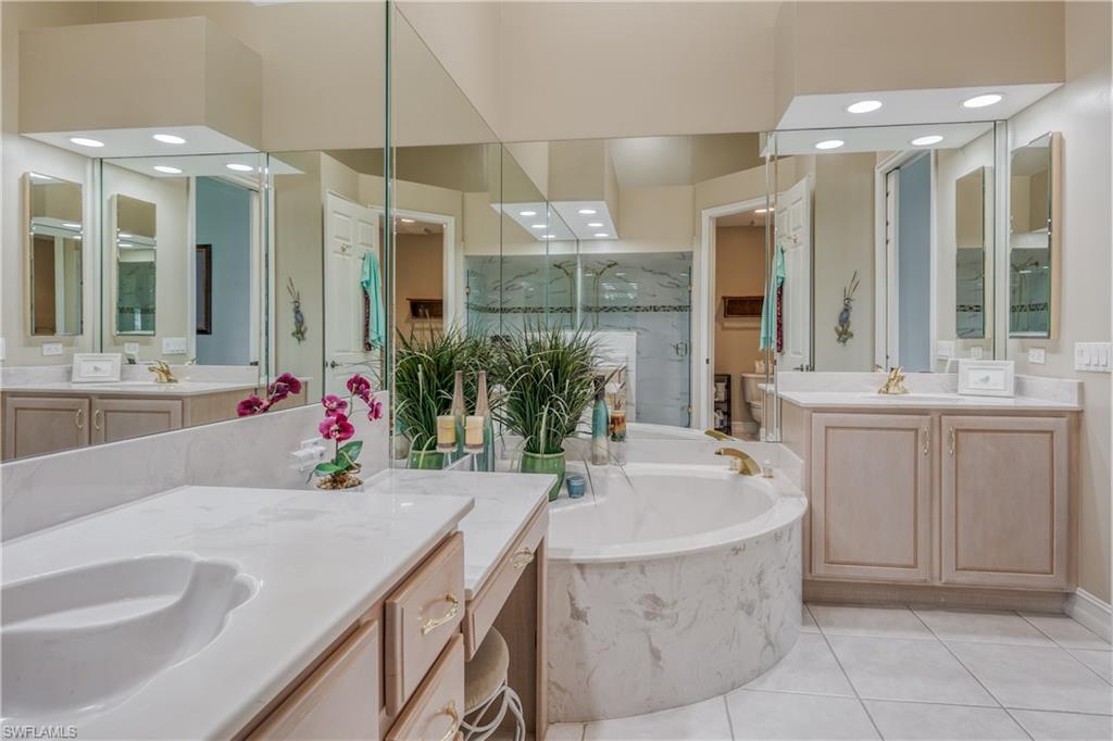6017 Trophy Drive, Unit 603 Naples, FL 34110 - Photo 9 of 23 a bathroom with a tub sink and mirror