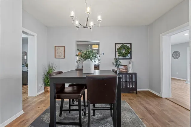 a dining room with furniture potted plants and wooden floor