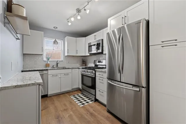 a view of a kitchen cabinets a refrigerator and wooden floor