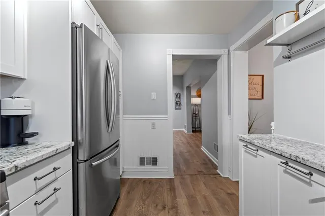 a kitchen that has a lot of cabinets in it and wooden floors