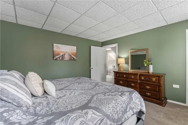 a bedroom with a bed and a large mirror on the dresser