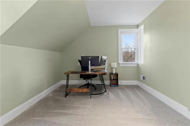 a view of an empty room with furniture and a window