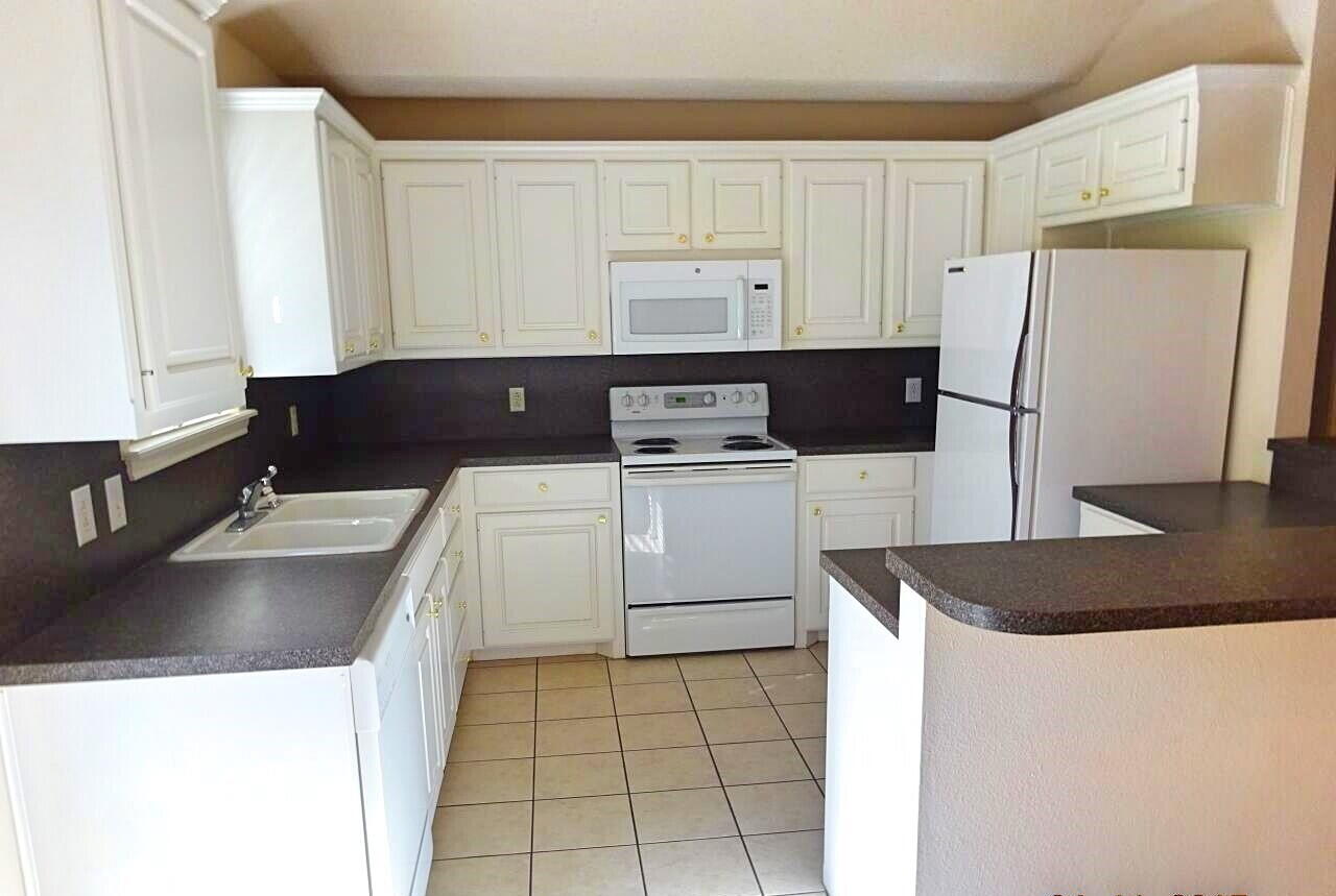 10108 Evanston Avenue, Unit 2 Lubbock, TX 79424 - Photo 3 of 8 a kitchen with a sink a stove and refrigerator