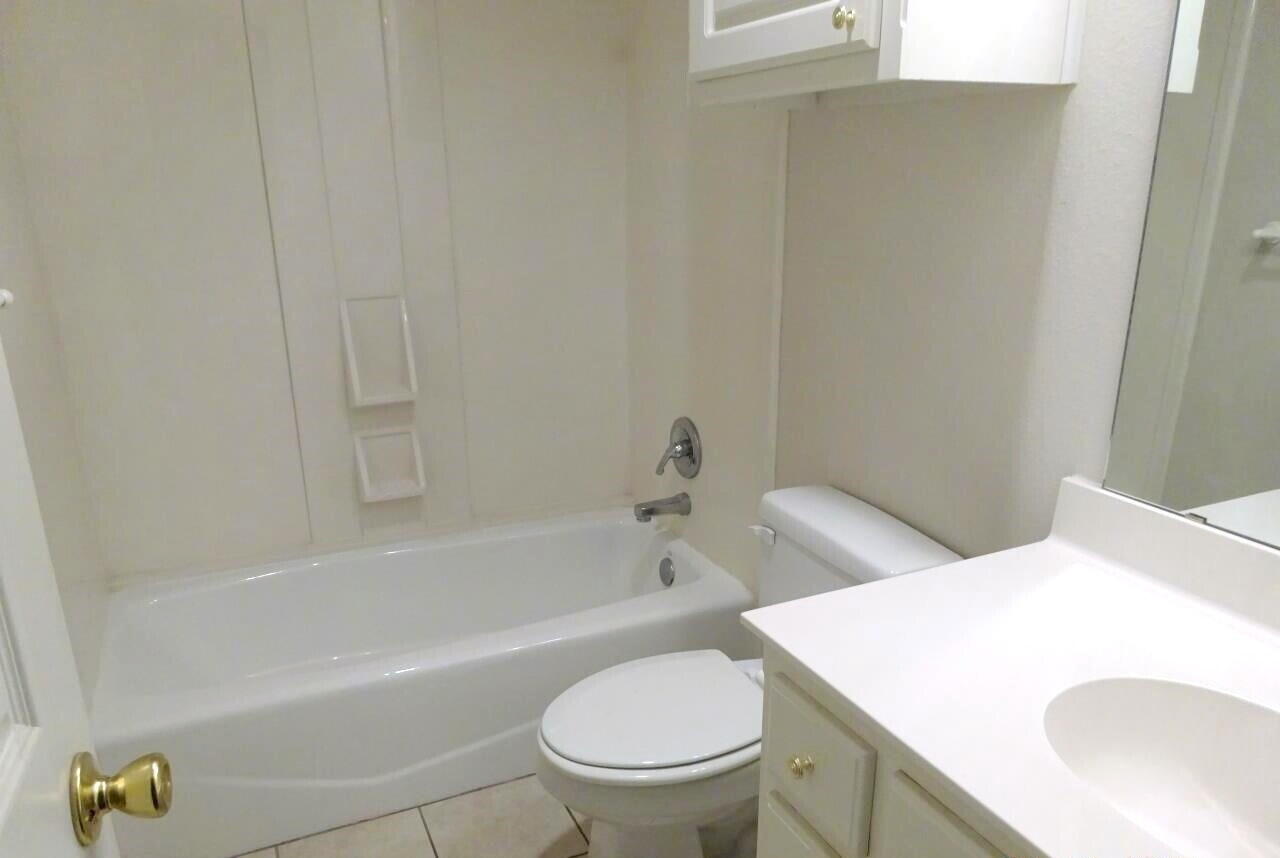 10108 Evanston Avenue, Unit 2 Lubbock, TX 79424 - Photo 6 of 8 a bathroom with a sink a toilet and bathtub