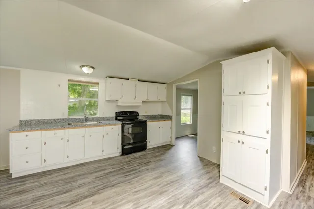 a kitchen with granite countertop white cabinets and white appliances