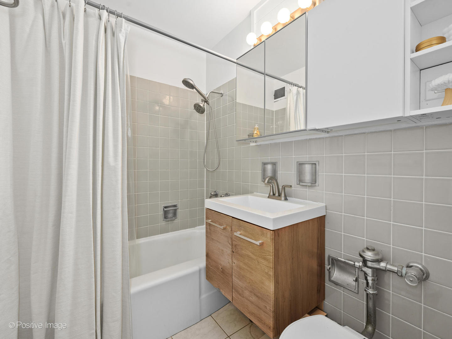 6118 North Sheridan Road, Unit 1003 Chicago, IL 60660 - Photo 11 of 13 a bathroom with a sink toilet vanity and shower