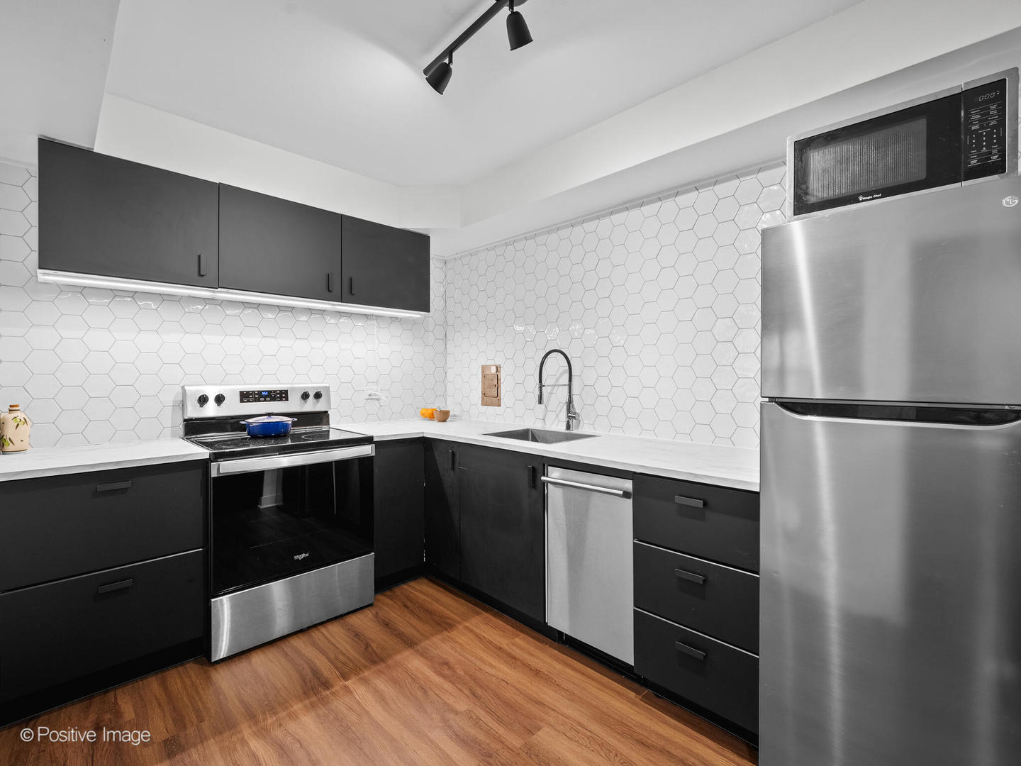 6118 North Sheridan Road, Unit 1003 Chicago, IL 60660 - Photo 6 of 13 a kitchen with stainless steel appliances a sink and a refrigerator
