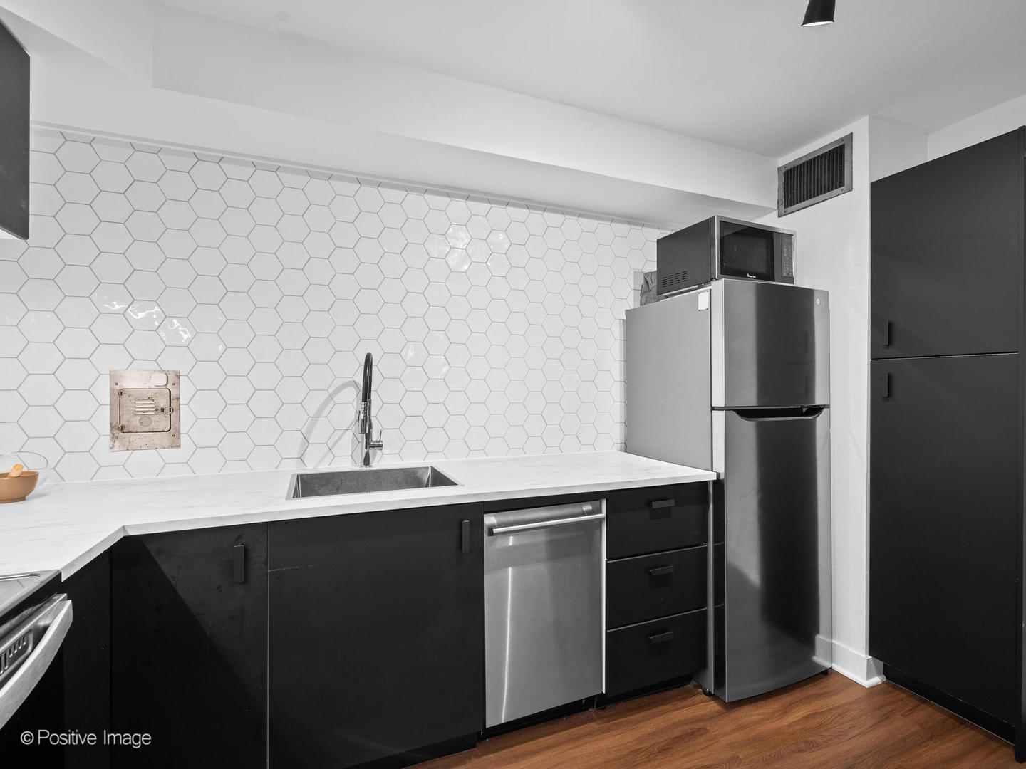 6118 North Sheridan Road, Unit 1003 Chicago, IL 60660 - Photo 7 of 13 a kitchen with a sink and a refrigerator