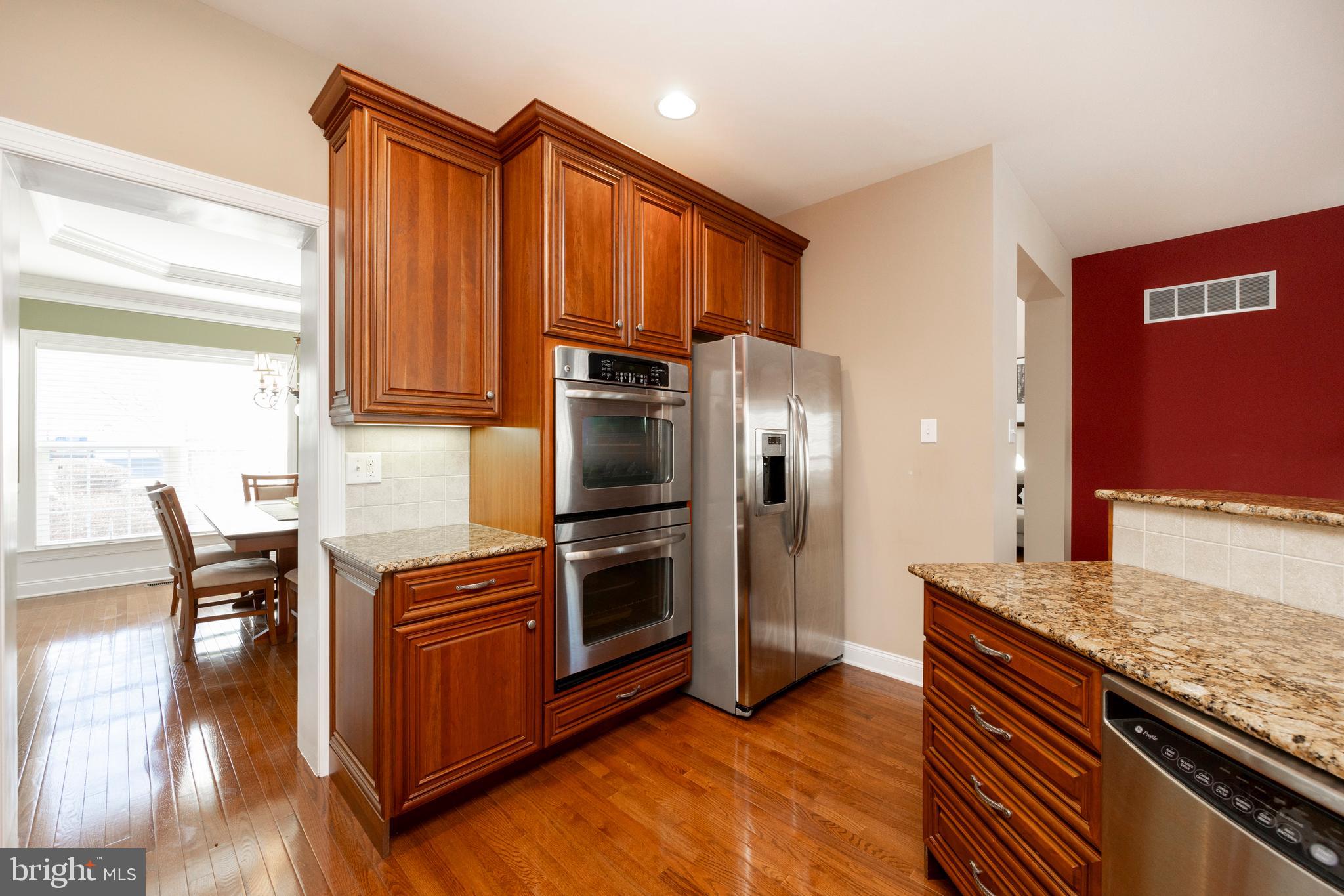 29 Ashtree Lane Malvern, PA 19355 - Photo 17 of 39 a kitchen with stainless steel appliances granite countertop a stove top oven a sink dishwasher and a refrigerator with wooden floor
