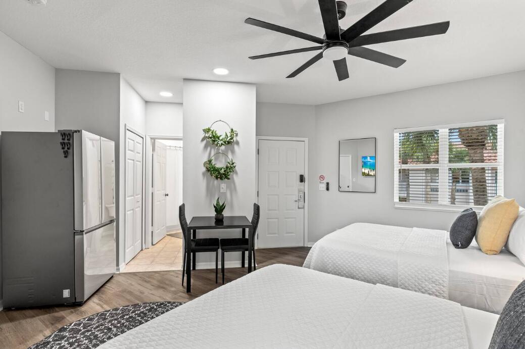 9969 Perfect Drive, Unit B Port St. Lucie, FL 34986 - Photo 7 of 8 a bedroom with a bed dresser and a window